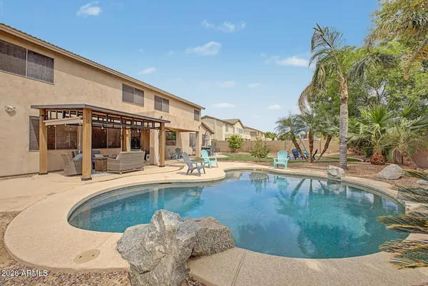 a view of a house with swimming pool and sitting area