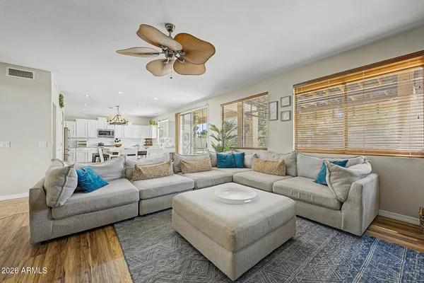 a living room with furniture wooden floor and a large window