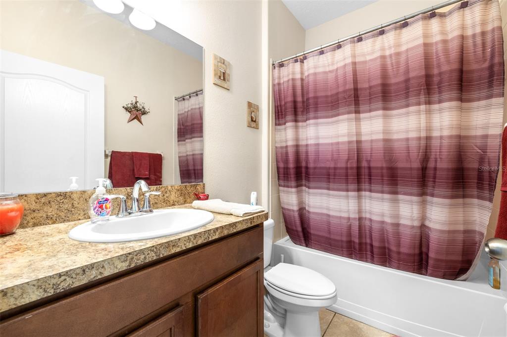 1564 Imperial Key Drive Trinity, FL 34655 - Photo 14 of 40 a bathroom with a sink a toilet and shower curtain