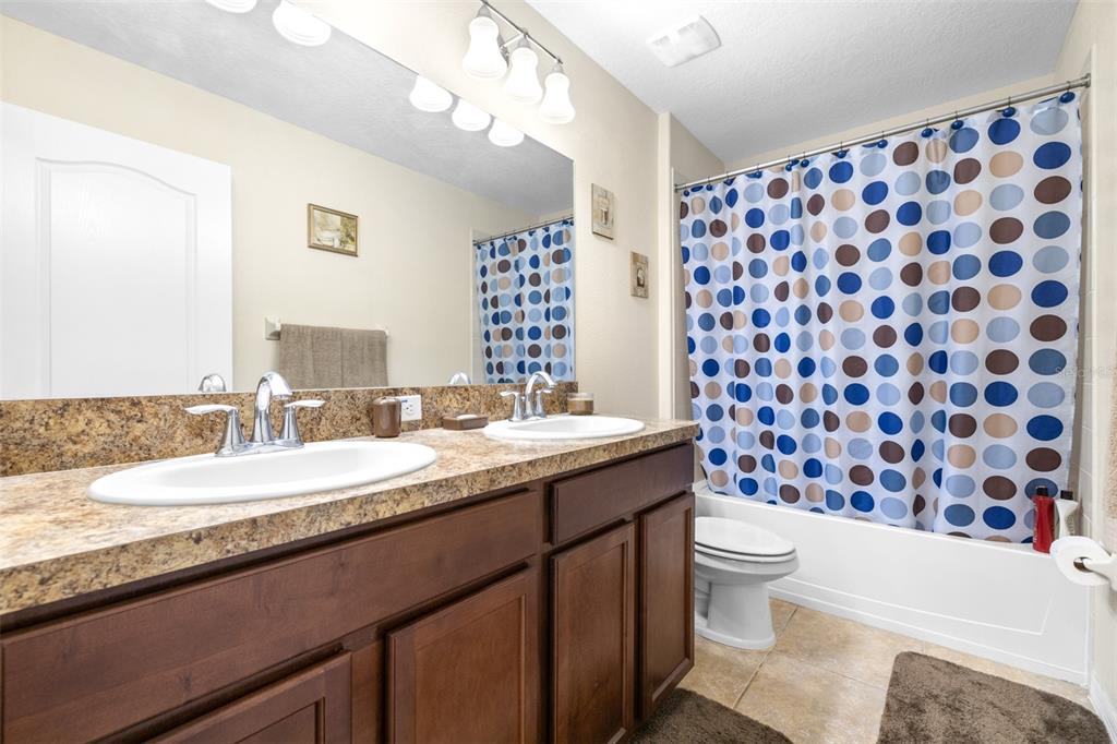 1564 Imperial Key Drive Trinity, FL 34655 - Photo 24 of 40 a bathroom with a granite countertop toilet sink and mirror