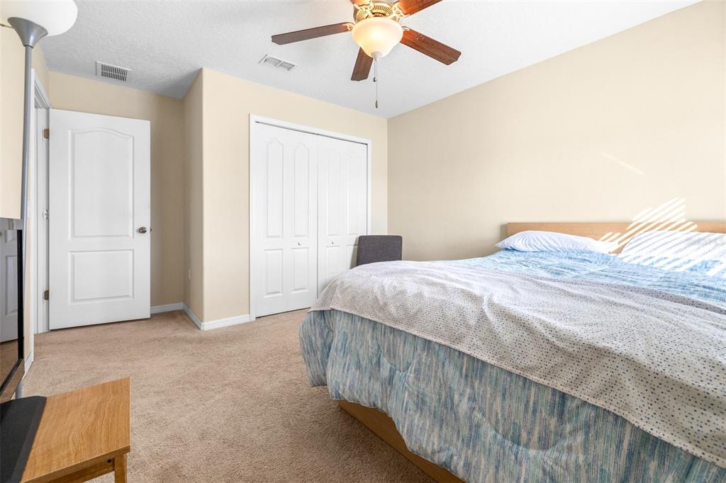 1564 Imperial Key Drive Trinity, FL 34655 - Photo 26 of 40 a bedroom with a bed and a chandelier