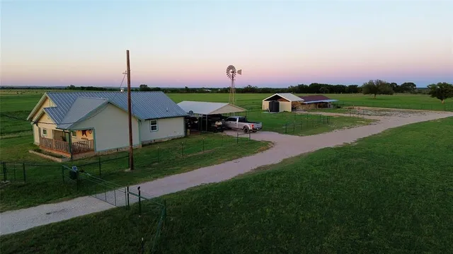 a front view of a house with a yard and green space