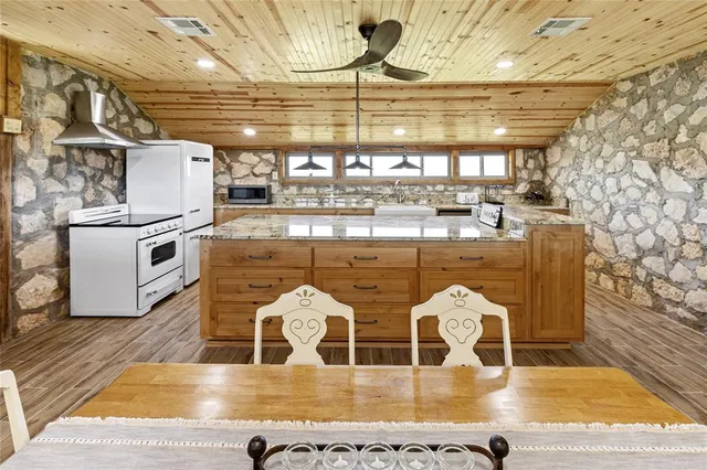 a kitchen with stainless steel appliances granite countertop a sink and wooden cabinets