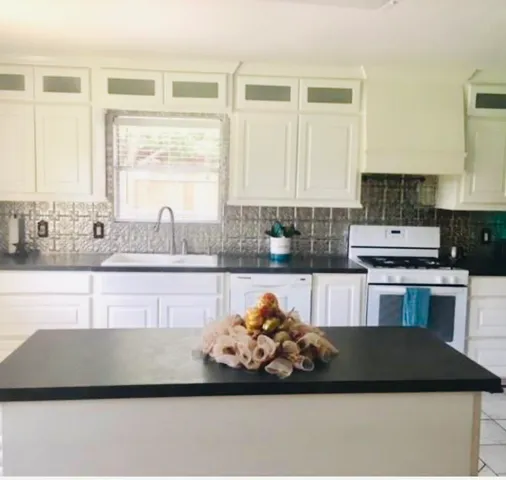 a kitchen with a sink cabinets and window