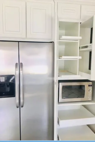 a kitchen with a refrigerator and cabinets