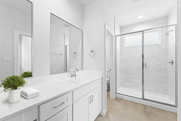 a spacious bathroom with a shower sink and mirror