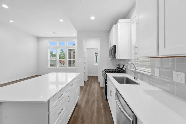 a kitchen with a sink a counter top space stainless steel appliances and cabinets