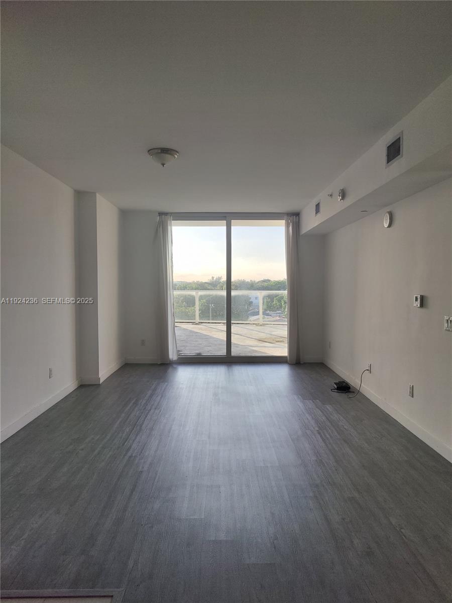 4250 Biscayne Boulevard, Unit 514 Miami, FL 33137 - Photo 11 of 16 wooden floor in an empty room with a window