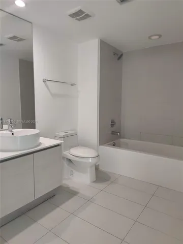 a bathroom with a toilet a sink a mirror and bathtub