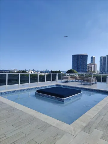 a swimming pool with outdoor seating and city view