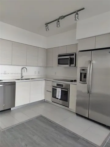a kitchen with stainless steel appliances a refrigerator sink and microwave