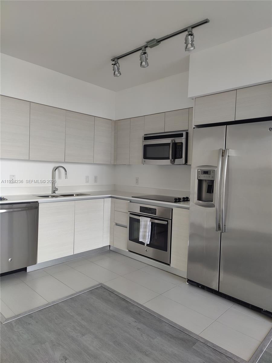 4250 Biscayne Boulevard, Unit 514 Miami, FL 33137 - Photo 9 of 16 a kitchen with stainless steel appliances a refrigerator sink and microwave