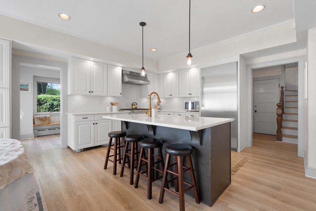 20 Eulow Street Swampscott, MA 01907 - Photo 5 of 42 a kitchen with kitchen island a sink stove and white cabinets with wooden floor