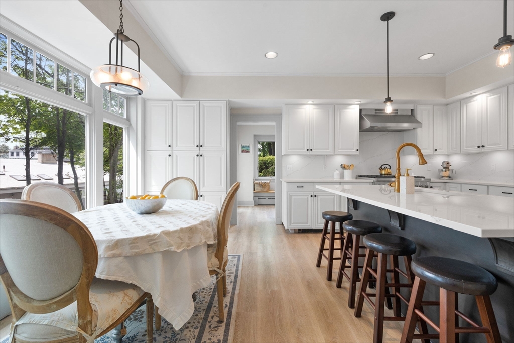 20 Eulow Street Swampscott, MA 01907 - Photo 7 of 42 a kitchen with stainless steel appliances granite countertop a stove a sink a dining table and chairs with wooden floor