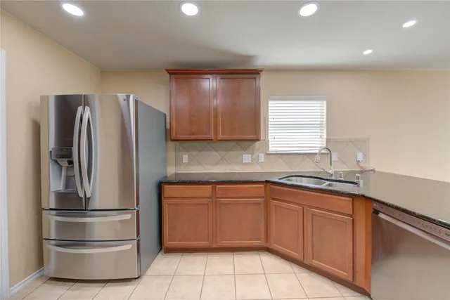a kitchen with stainless steel appliances granite countertop a refrigerator sink and cabinets