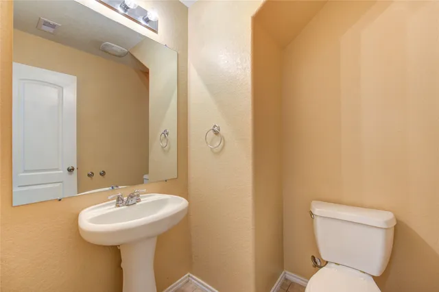 a bathroom with a sink toilet and a mirror