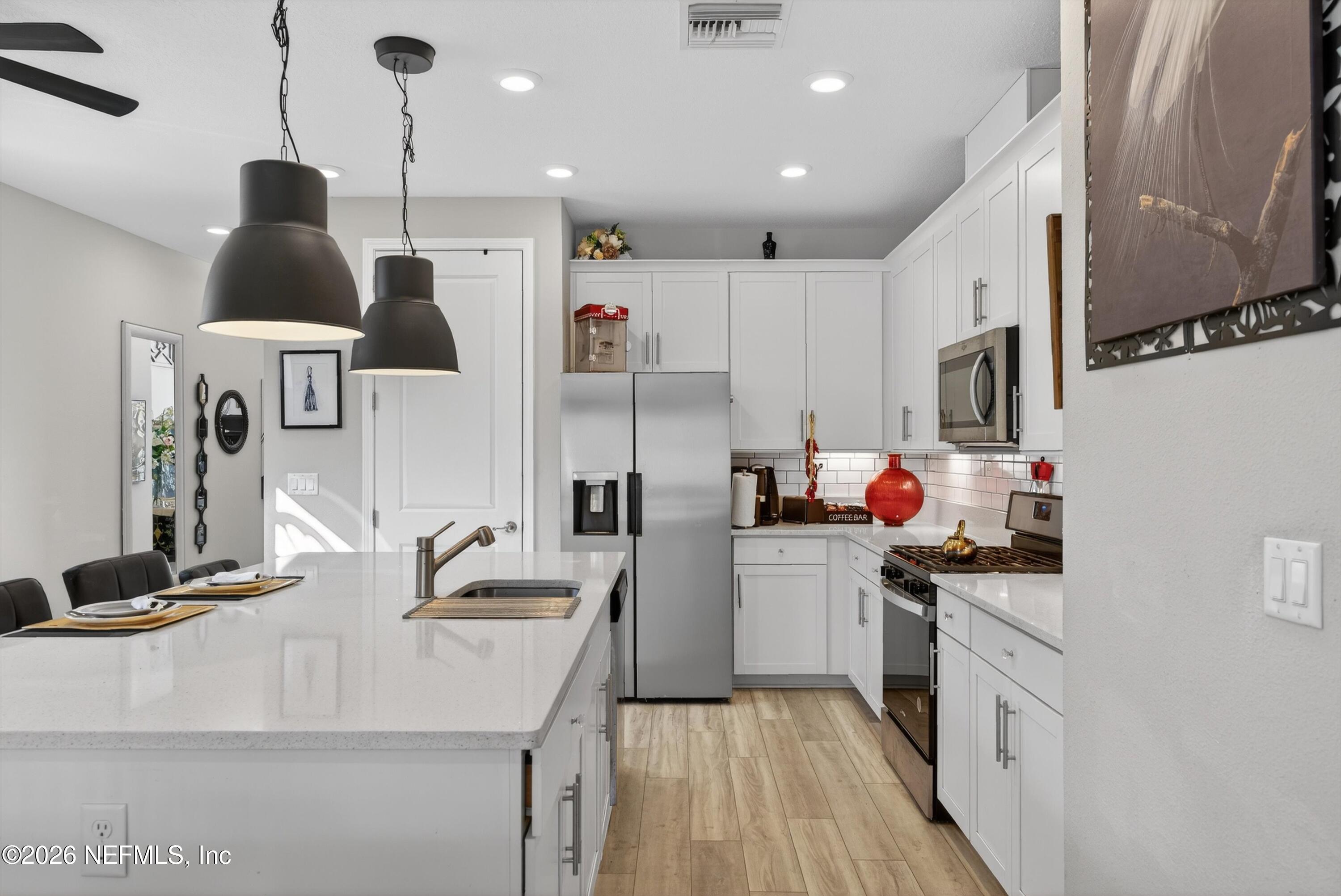 1055 Rustic Mill Dr Street St. Augustine, FL 32092 - Photo 17 of 87 a kitchen with stainless steel appliances kitchen island granite countertop a sink and a refrigerator
