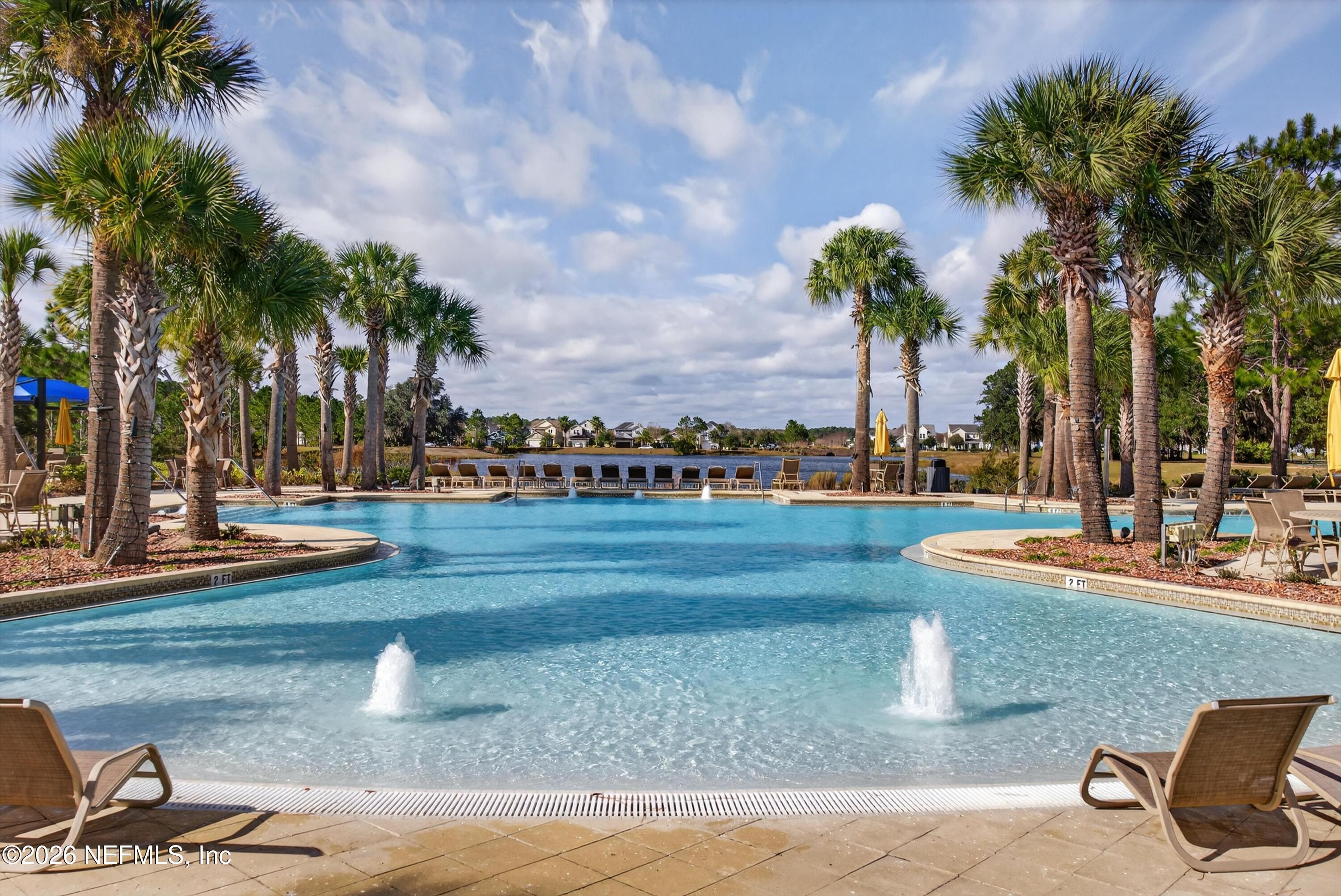 1055 Rustic Mill Dr Street St. Augustine, FL 32092 - Photo 70 of 87 a view of a swimming pool with a lawn chairs and palm trees
