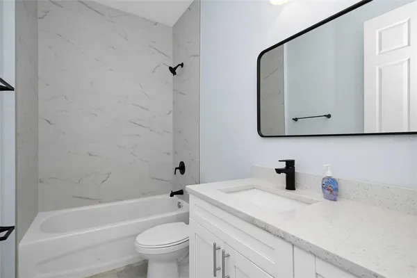 a bathroom with a sink a toilet and bathtub
