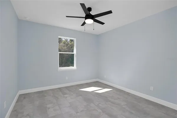 an empty room with a window and a fan