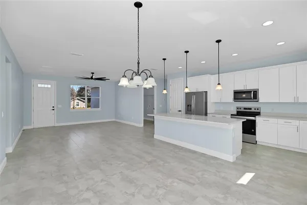 a view of a kitchen with kitchen island a sink stainless steel appliances and a counter top