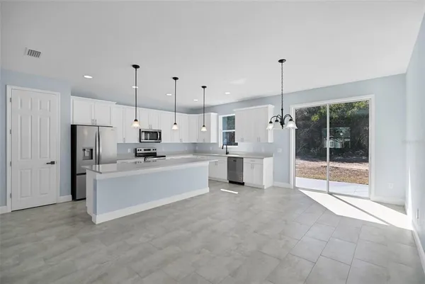 a large white kitchen with stainless steel appliances