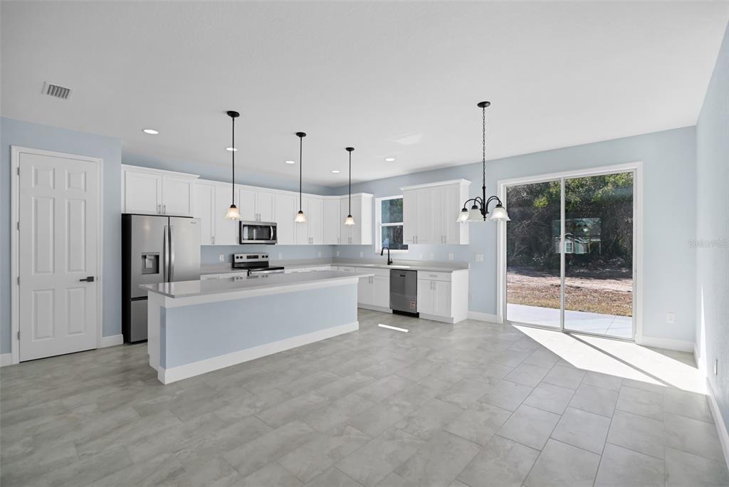 7604 Southwest 103rd Loop Ocala, FL 34476 - Photo 6 of 20 a large white kitchen with stainless steel appliances