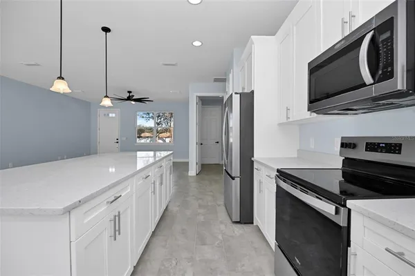 a kitchen with stainless steel appliances a stove microwave and a refrigerator