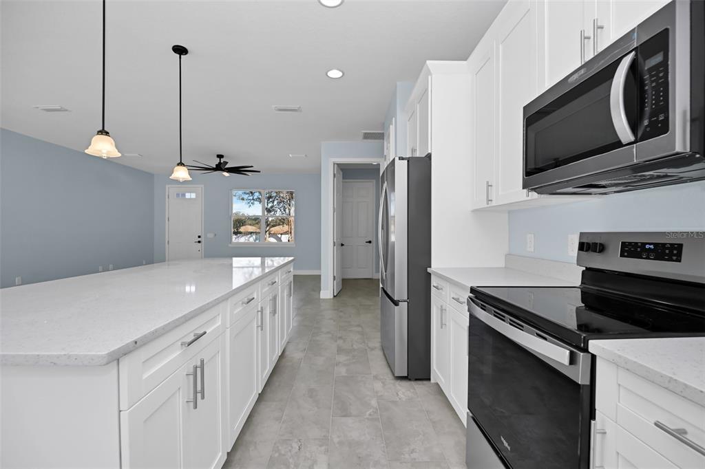 7604 Southwest 103rd Loop Ocala, FL 34476 - Photo 8 of 20 a kitchen with stainless steel appliances a stove microwave and a refrigerator