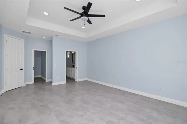 an empty room with closet and a ceiling fan