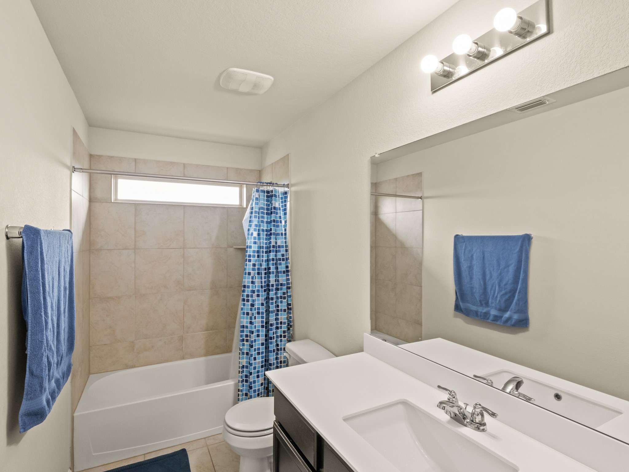 574 Nautical Loop Kyle, TX 78640 - Photo 16 of 23 A well-lit bathroom features a single vanity, a spacious tub, and tiled shower walls for comfort and function.