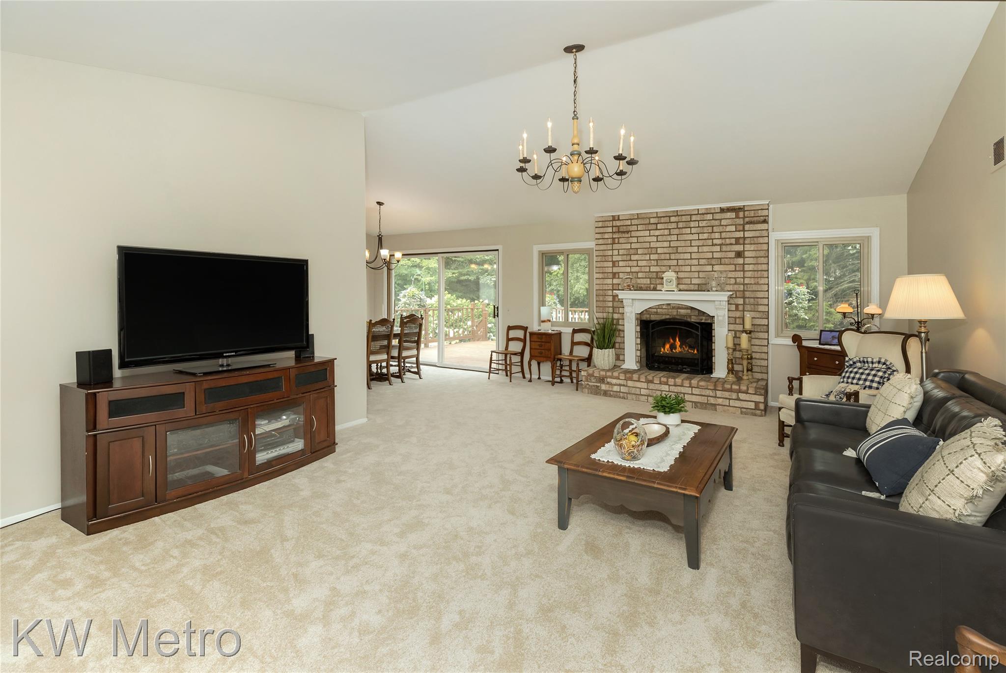2154 Warrington Road Rochester, MI 48307 - Photo 10 of 41 Living room featuring a brick fireplace with a white mantel, vaulted ceiling, and carpet flooring