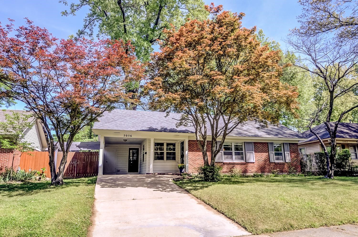 Ranch-style house featuring a carport, concrete driveway, brick siding, and a shingled roof