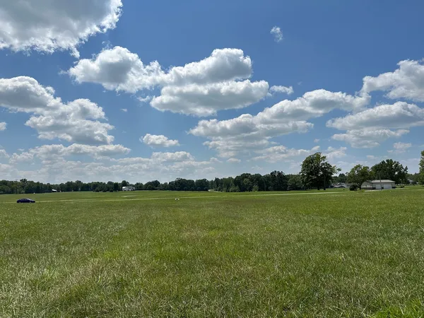 a view of a big yard with lots of buildings and a lake