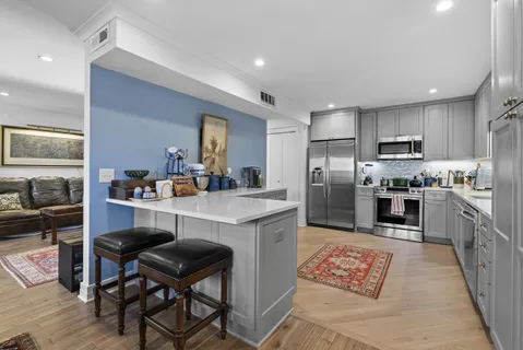 a kitchen with kitchen island granite countertop wooden cabinets and stainless steel appliances