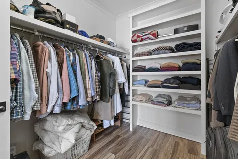 a view of walk in closet with clothes and shoes