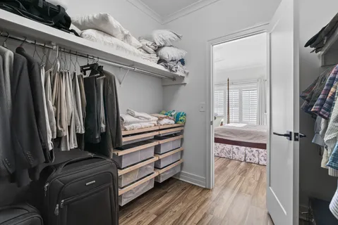 a view of walk in closet with clothes and shoes