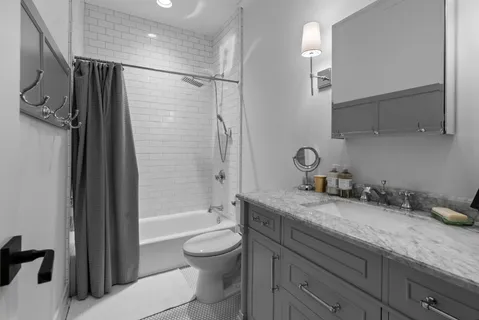 a bathroom with a granite countertop sink a toilet a mirror and shower
