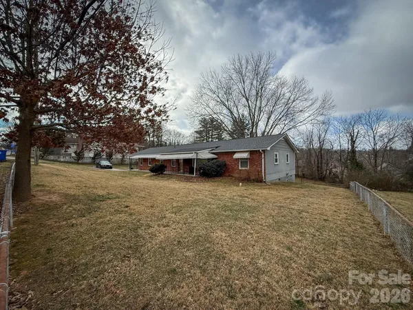 a front view of a house with a yard and trees