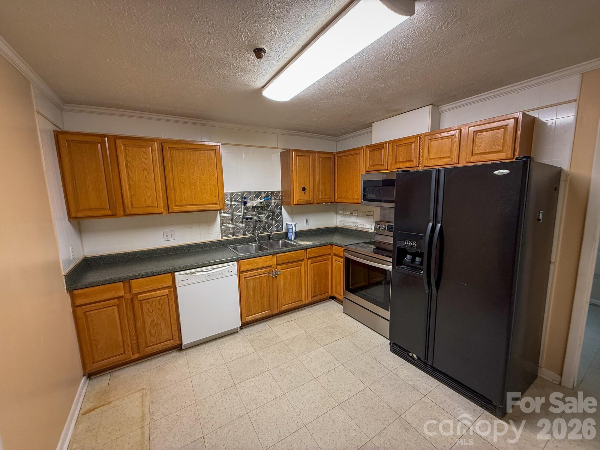 483 Caribou Road Asheville, NC 28803 - Photo 14 of 26 a kitchen with granite countertop a refrigerator a sink a stove a microwave a counter top space and cabinets