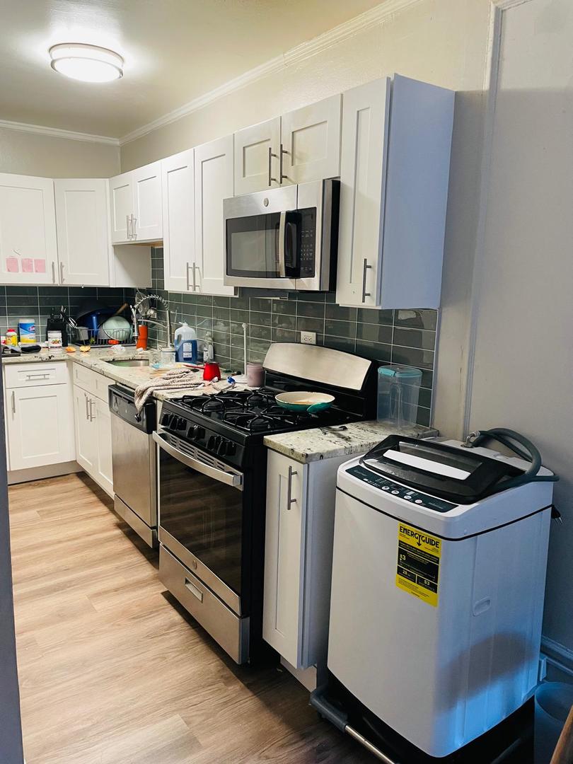 451 West Melrose Street, Unit 404 Chicago, IL 60657 - Photo 4 of 9 a kitchen with stainless steel appliances granite countertop a stove a sink and a microwave