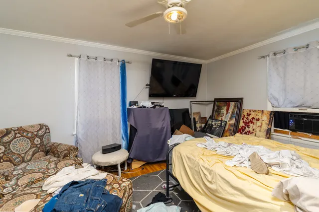 a bed sitting in a bedroom next to a window with a flat tv screen and dresser