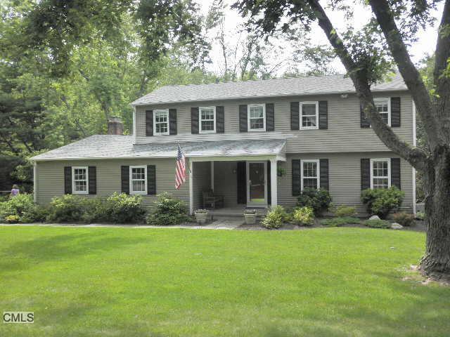 a front view of a house with a yard and trees