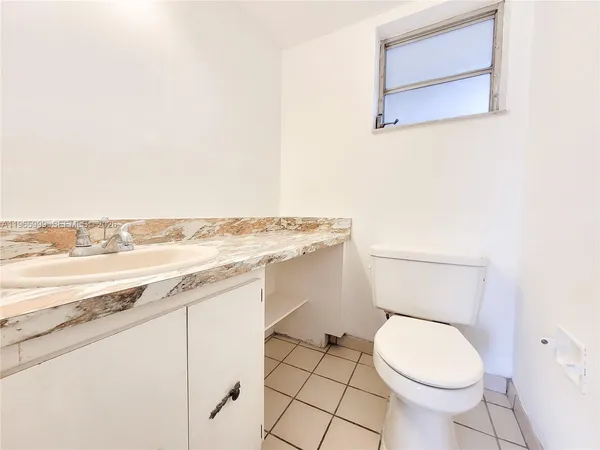 a bathroom with a toilet a sink and a mirror