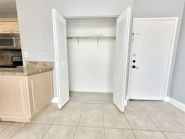 a view of a kitchen with white cabinets and entryway