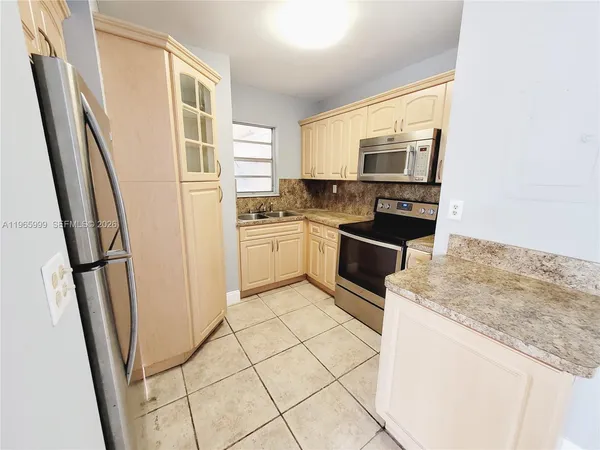 a kitchen with stainless steel appliances granite countertop a refrigerator stove and sink