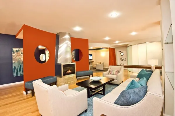 a kitchen with stainless steel appliances kitchen island granite countertop a table chairs and a wooden floor