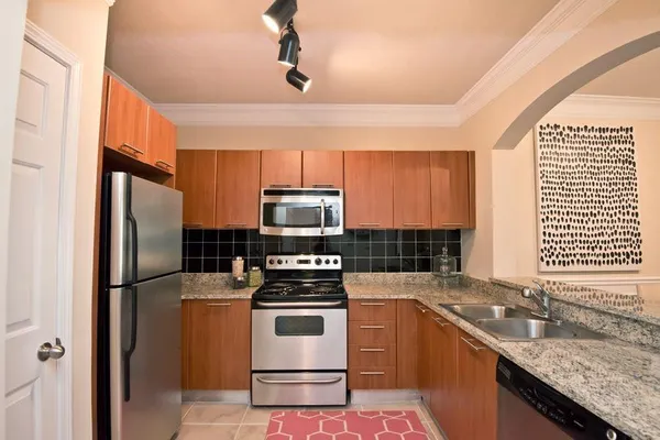 a kitchen with stainless steel appliances granite countertop a stove a refrigerator and a sink