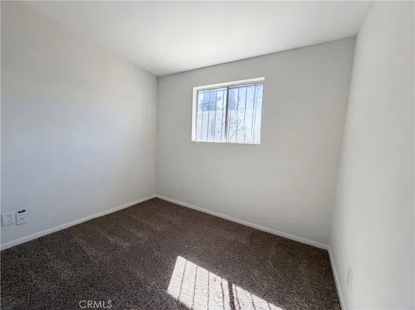an empty room with a ceiling fan and a window