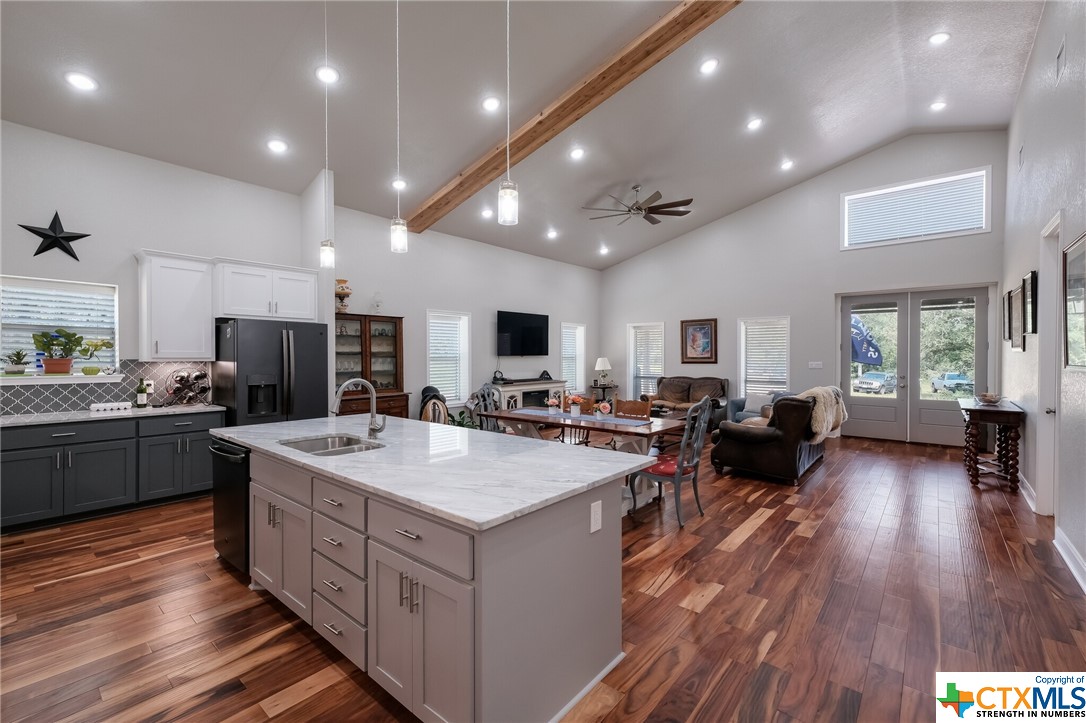 a large kitchen with stainless steel appliances a large center island and a wooden floors